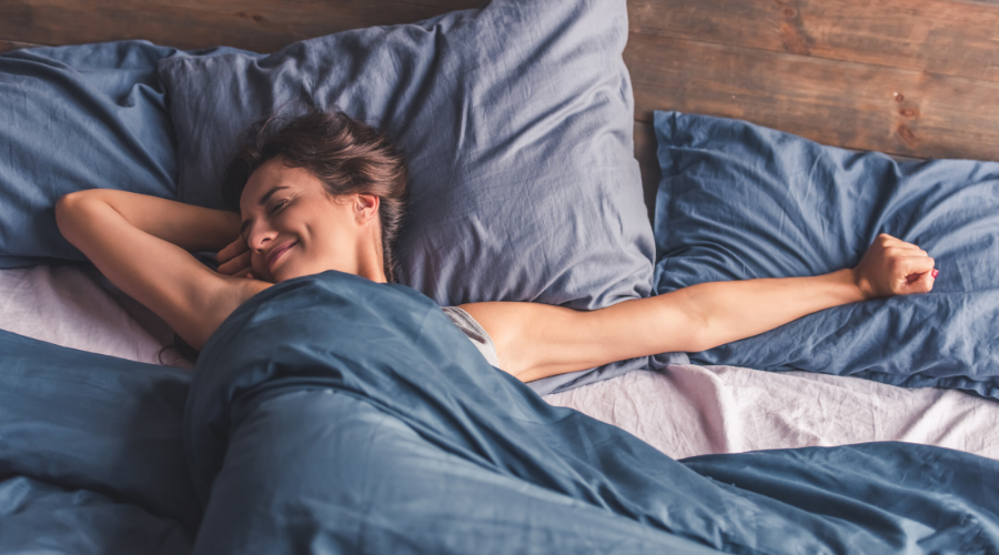 Vrouw rekt zich uit in bed - Bodystore.nl